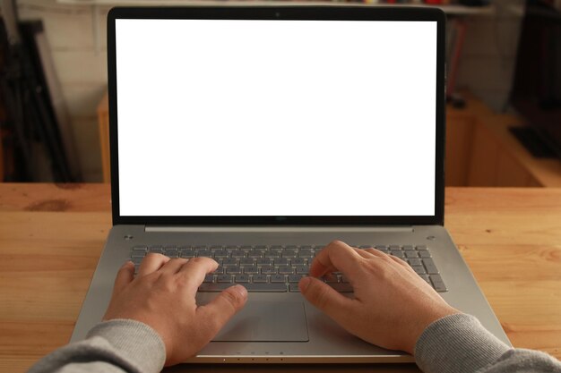 Imagen en primer plano de una computadora portátil con pantalla blanca. Hombre escribiendo en una computadora portátil.