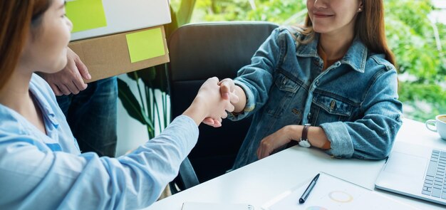 Foto imagen en primer plano de dos jóvenes empresarios estrechando la mano en la oficina