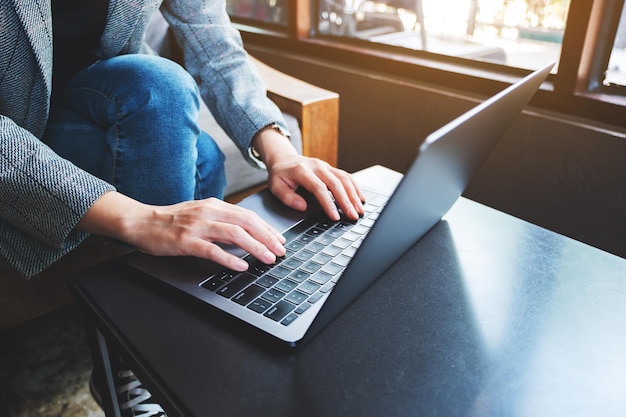 Imagen de primer plano de una empresaria trabajando y escribiendo en la computadora portátil