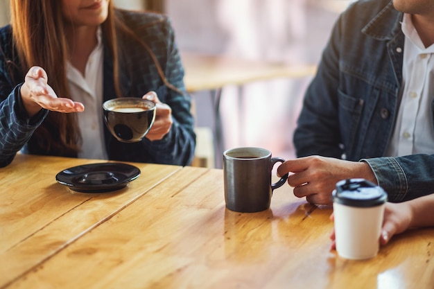 Imagen de primer plano de la gente disfrutaba hablando y bebiendo café juntos en la cafetería