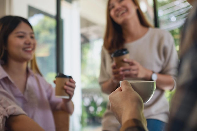 Foto imagen de primer plano de un grupo de jóvenes que disfrutaban hablando y bebiendo café juntos