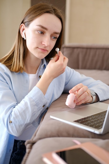 Foto imagen en primer plano de una hermosa joven alegre con ropa casual usando auriculares bluetooth