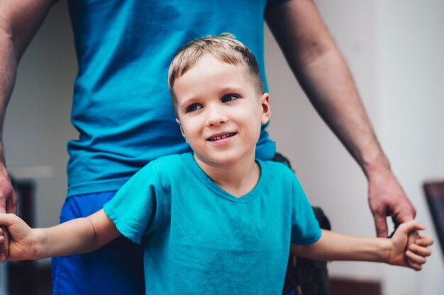 Imagen en primer plano de un hijo tierno abrazando las manos de su padre.