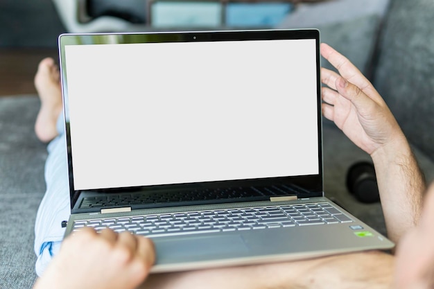 Imagen de primer plano de un hombre acostado en la cama trabajando en una computadora portátil Toma POV de un hombre relajándose en el dormitorio usando una computadora con pantalla táctil Espacio de copia El espacio está vacío para texto y diseño