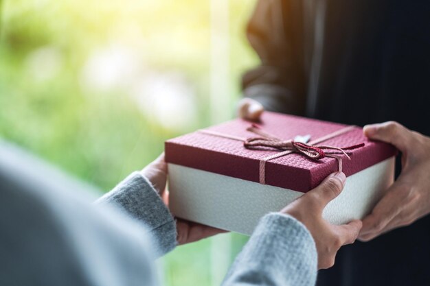 Imagen de primer plano de un hombre que le da a una mujer una caja de regalo