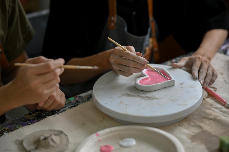 Foto imagen de primer plano de un hombre que disfruta pintando un plato de cerámica en un taller de artesanía creativa