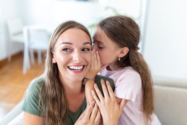 Imagen de primer plano madre asombrada escucha noticias increíbles de una hija pequeña que comparte un secreto contando algo interesante mientras que mamá con la boca abierta se siente sorprendida confiando en el concepto divertido de la persona confidente