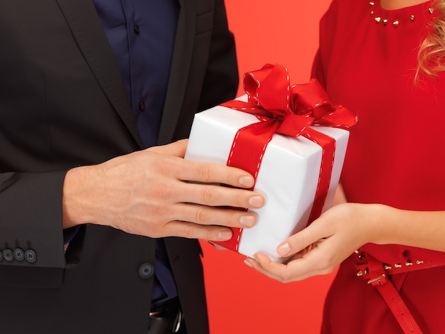 Imagen en primer plano de las manos del hombre y la mujer con caja de regalo
