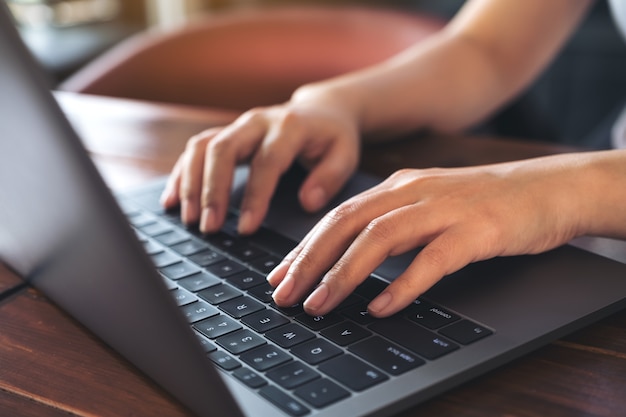 Imagen de primer plano de las manos de una mujer de negocios trabajando y escribiendo en el teclado de una computadora portátil