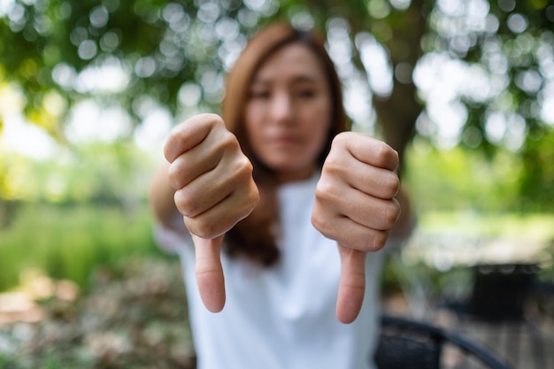 Foto imagen de primer plano de una mujer haciendo el pulgar hacia abajo signo de manos