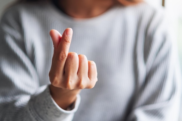 Imagen de primer plano de una mujer joven haciendo y mostrando el signo de la mano del corazón mini