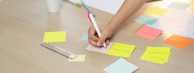 Foto imagen de primer plano de una mujer de negocios con la mano colocada en notas adhesivas de colores variadas