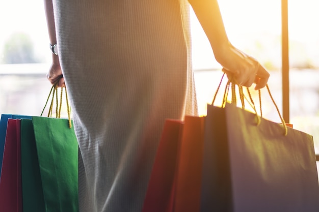 Imagen de primer plano de una mujer sosteniendo coloridas bolsas de la compra.