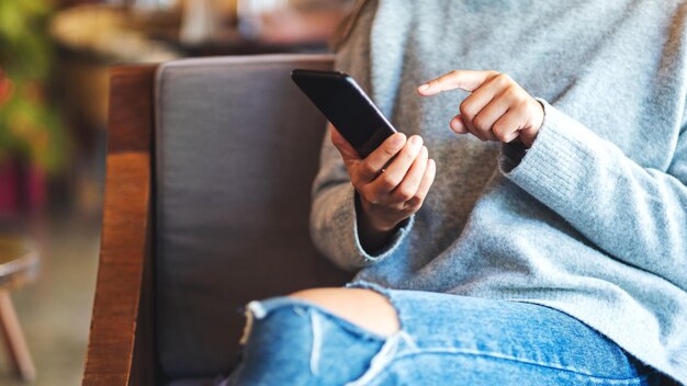 Imagen de primer plano de una mujer sosteniendo y usando un teléfono inteligente