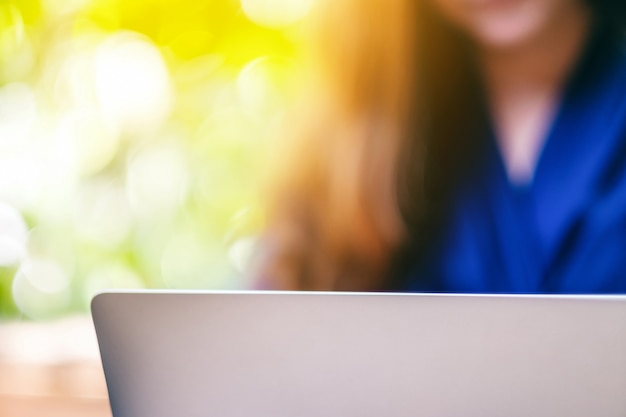 Foto imagen de primer plano de una mujer trabajando y usando una computadora portátil al aire libre