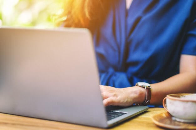 Imagen de primer plano de una mujer trabajando y usando una computadora portátil al aire libre