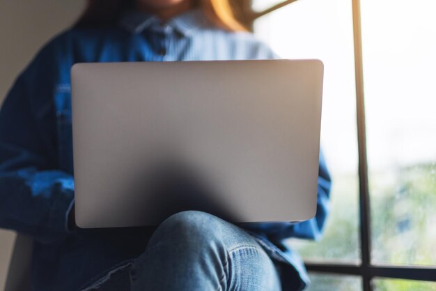 Imagen de primer plano de una mujer usando, trabajando y escribiendo en la computadora portátil