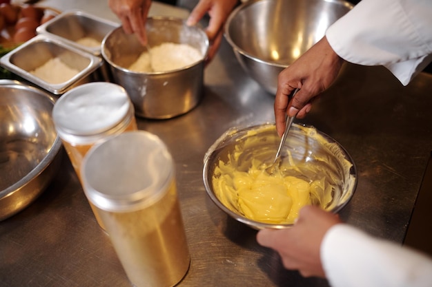 Imagen en primer plano de un panadero haciendo crema de mantequilla para pasteles