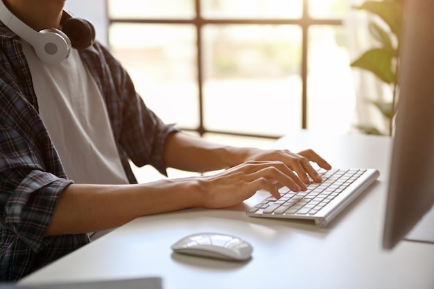 Foto imagen de primer plano de un programador masculino usando su computadora escribiendo en el teclado