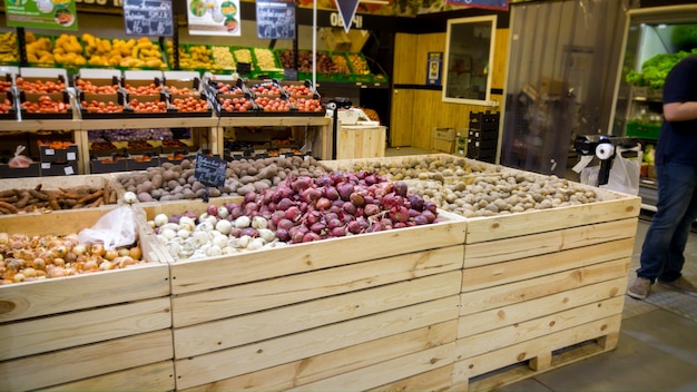 Imagen de primer plano de verduras frescas en cajas de madera en los mostradores de la tienda de comestibles