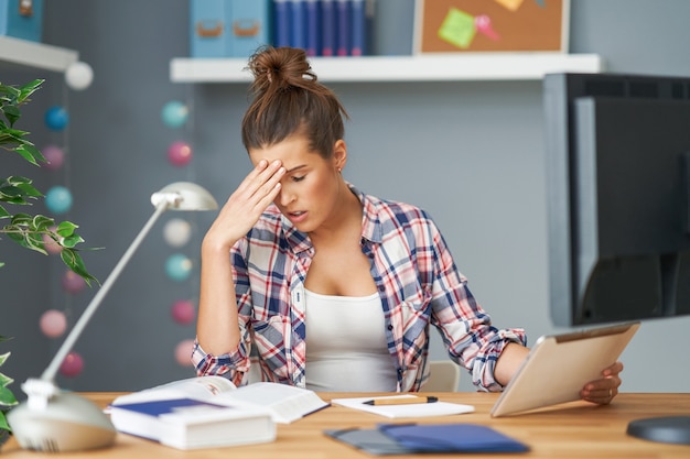 Foto imagen que muestra a una estudiante cansada que aprende tarde en casa