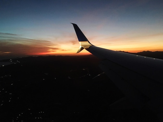 Foto imagen recortada del ala de un avión sobre el paisaje