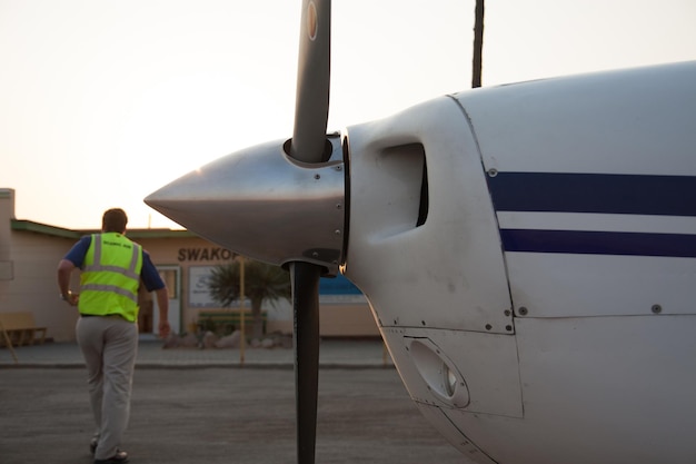 Foto imagen recortada de un avión en el aeropuerto contra un hombre caminando en el fondo