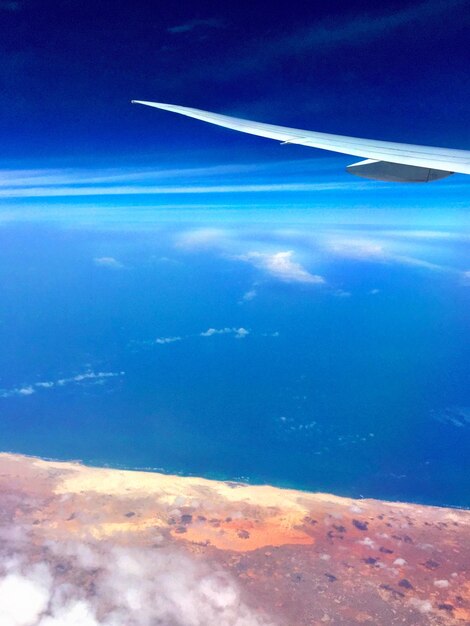 Foto imagen recortada de un avión volando sobre el paisaje