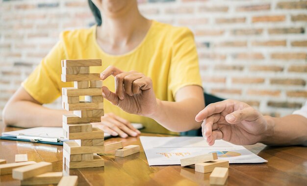 Foto imagen recortada de colegas jugando al juego de eliminación de bloques en la oficina