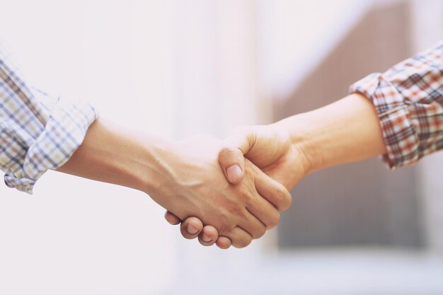 Foto imagen recortada de colegas de negocios estrechando la mano en la oficina