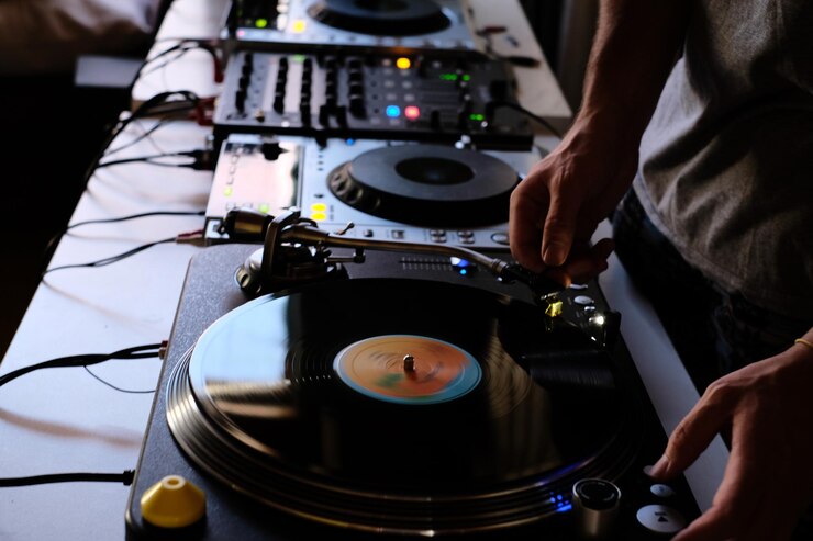 Foto imagen recortada de un dj tocando música desde un mezclador de sonido en la mesa