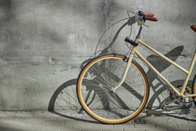 Imagen recortada de la elegante bicicleta vintage de pie al aire libre aislado en la pared gris