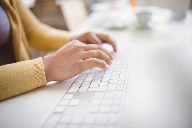 Imagen recortada de empresaria escribiendo en el teclado