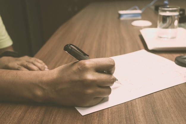 Foto imagen recortada de escritura a mano en papel en la mesa