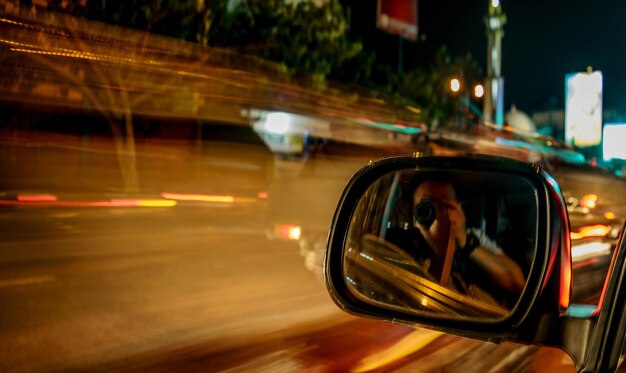 Foto imagen recortada del espejo del coche en la carretera por la noche