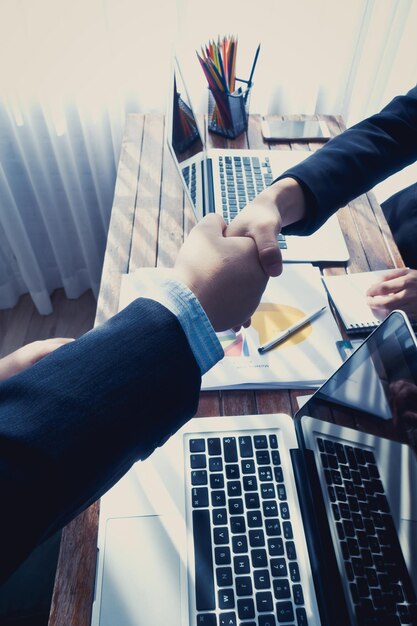 Foto imagen recortada de gente de negocios estrechando la mano en la oficina