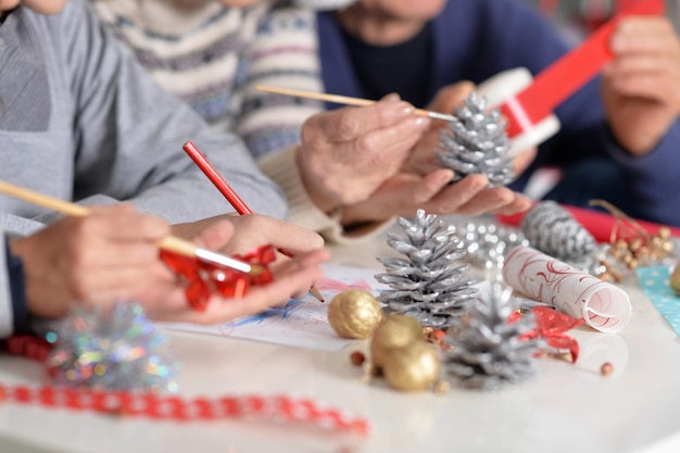 Imagen recortada de gran familia preparándose para la Navidad en casa