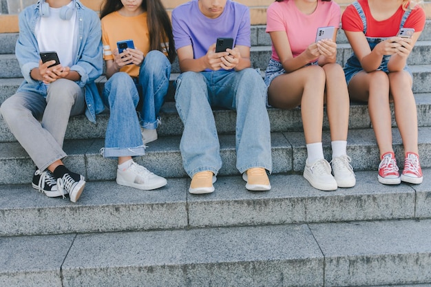 Foto imagen recortada de un grupo de adolescentes con teléfonos móviles viendo comunicación en video en línea