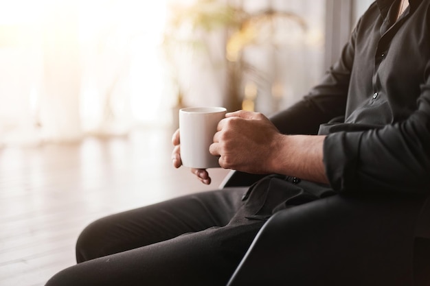 Imagen recortada de un hombre de negocios con una taza de café