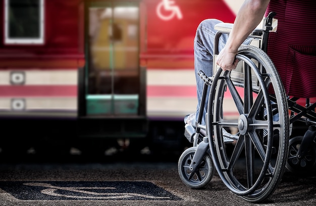 Imagen recortada del hombre en su silla de ruedas en la plataforma de la estación de ferrocarril