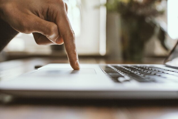 Foto imagen recortada de un hombre usando una computadora portátil en casa