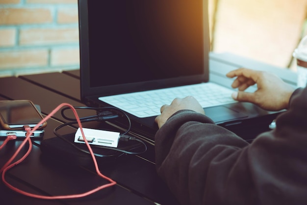 Imagen recortada de un hombre usando una computadora portátil en la mesa