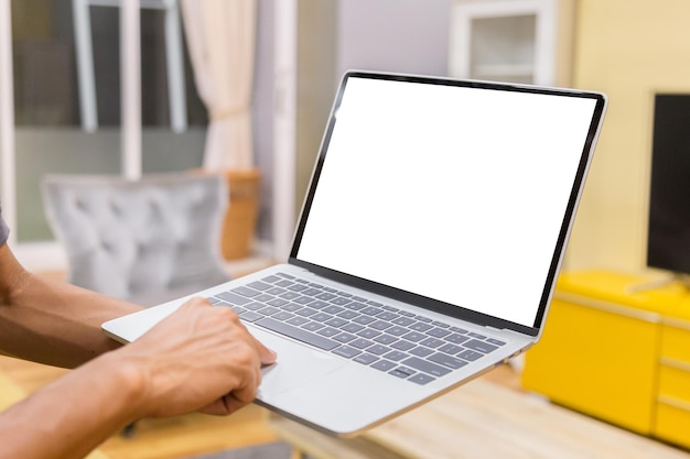 Imagen recortada de un hombre usando una computadora portátil en la mesa