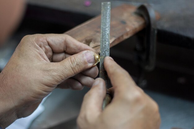 Imagen recortada de un joyero formando un anillo con rasp en el taller