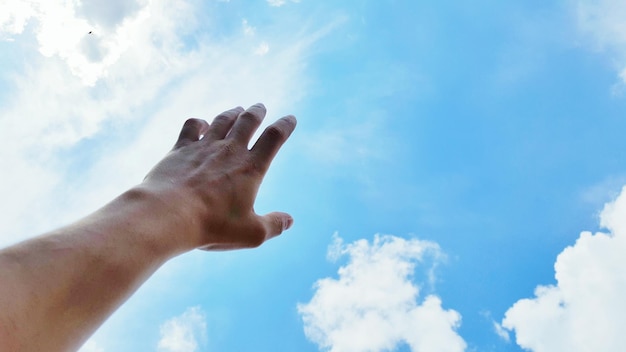 Imagen recortada de la mano contra el cielo