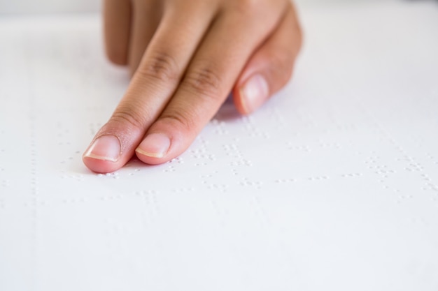 Imagen recortada de la mano del niño leyendo el libro braille