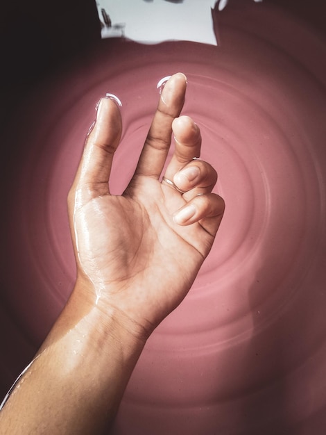 Foto imagen recortada de la mano de una persona en el agua.