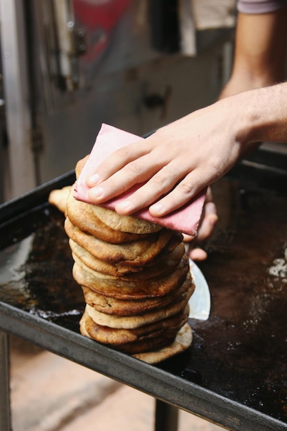 Foto imagen recortada de la mano en un sándwich de carne