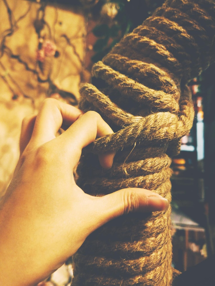 Foto imagen recortada de una mano sosteniendo una cuerda