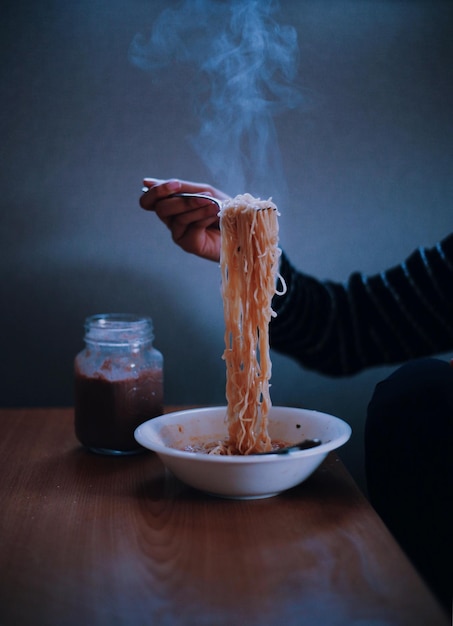 Imagen recortada de la mano sosteniendo fideos